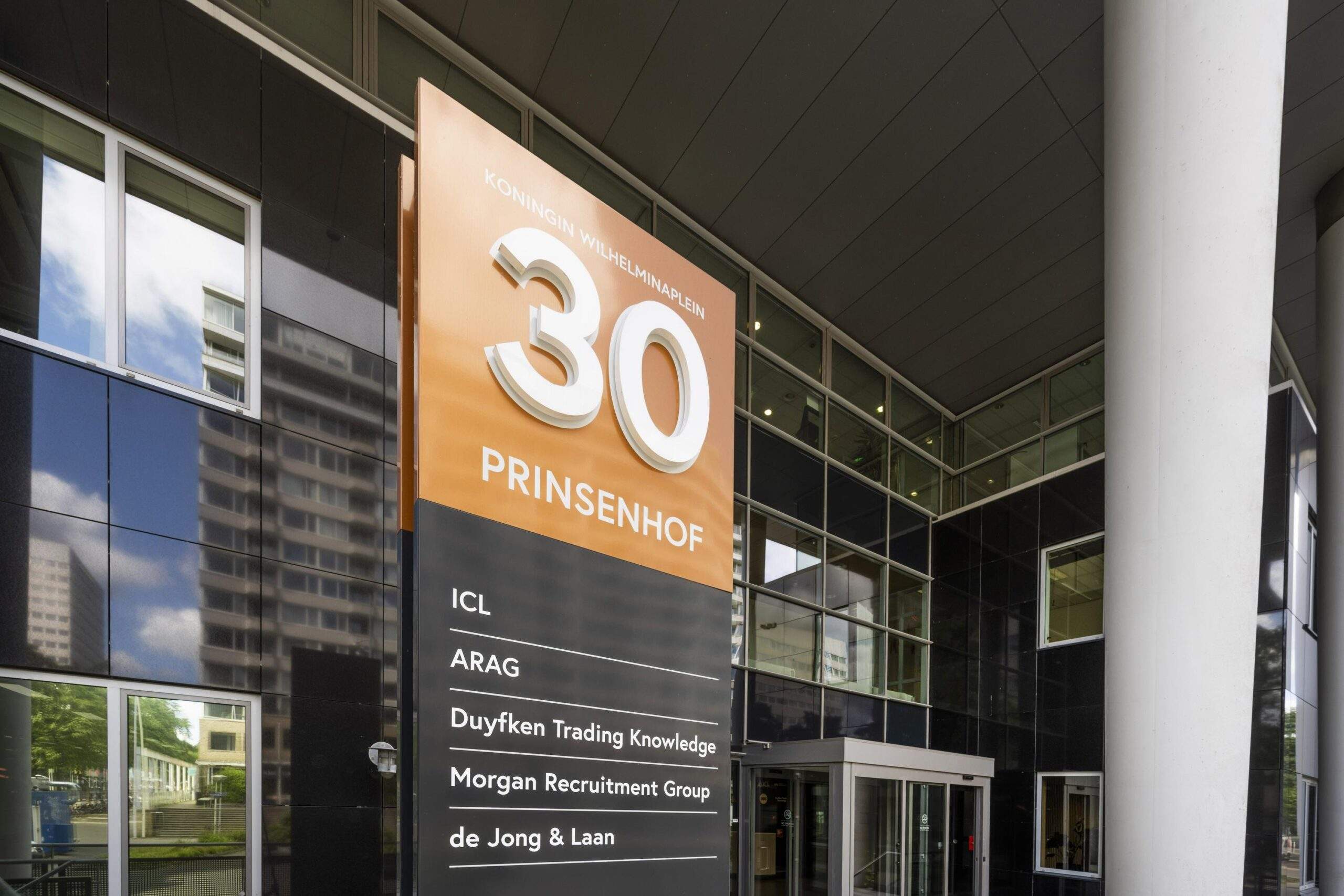 Ingang van het kantoorgebouw Prinsenhof aan het Koningin Wilhelminaplein 30 met een overzicht van de gevestigde bedrijven.